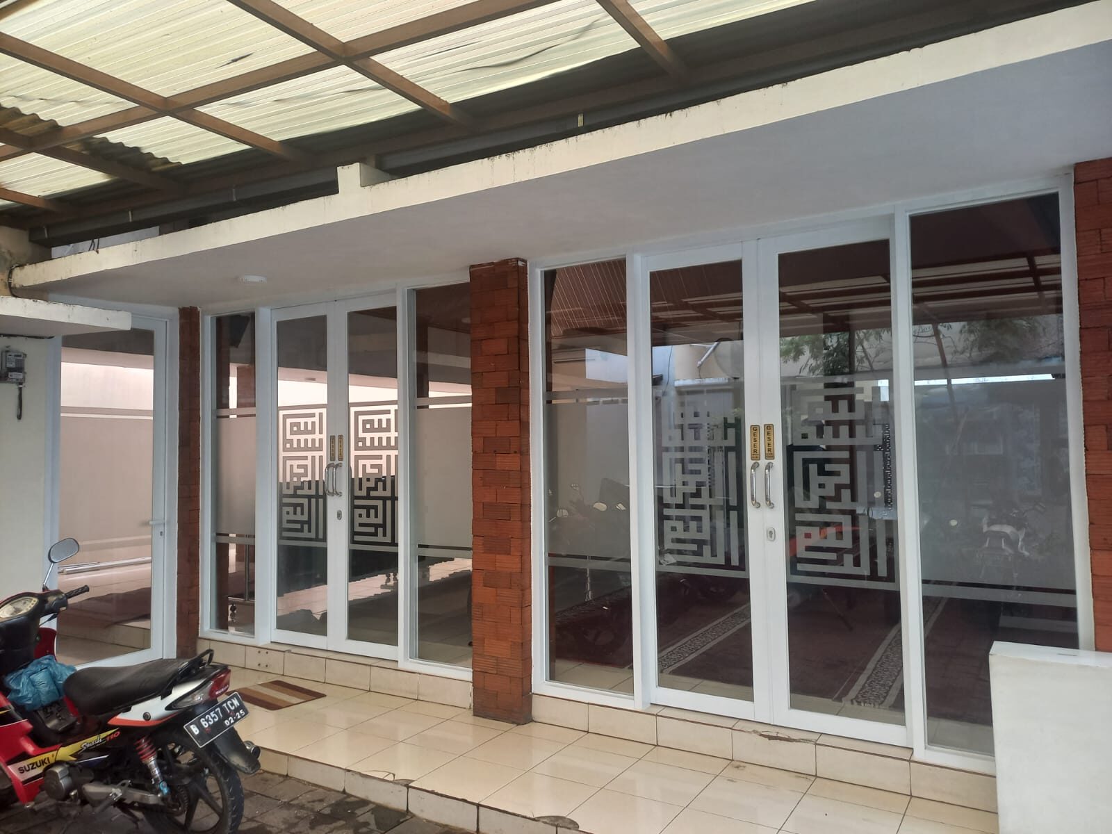 Pintu kaca geser dengan stiker kaligrafi kufi kotak